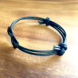Armbånd i sort læder med knude "knot" -Foto